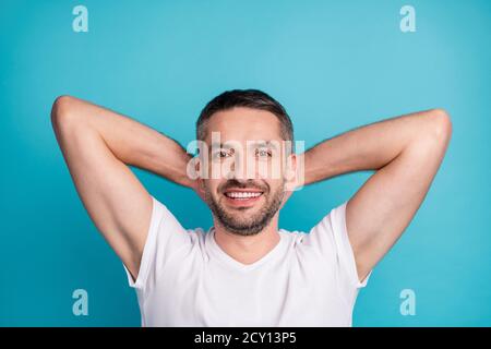 Gros plan portrait de son beau contenu attrayant sportif gai tricherie barbu gars portant une chemise tenant les mains derrière la tête reposant isolé sur Banque D'Images