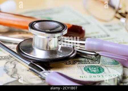Frais de médecine soins de santé assurance santé, stéthoscope dans le billet de banque de dollars d'argent, sur les tubes de test de sang Banque D'Images