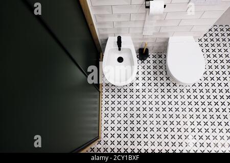 Vue de haut en bas d'une salle de bains moderne avec vert foncé placard et carrelage rétro noir et blanc de style rétro Banque D'Images