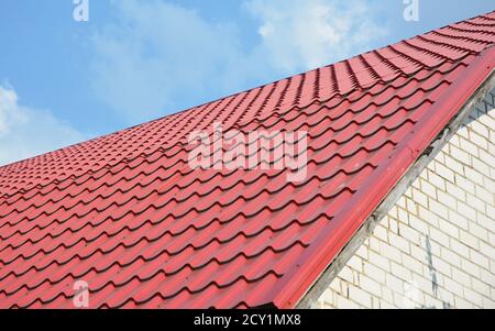 Construction d'une nouvelle maison avec un toit en métal rouge, construction de toiture à l'extérieur. Banque D'Images