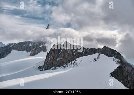 Trois alpinistes se sont rassemblés pour monter un glacier au Mont blanc et le pic de Gigant Tooth entouré de nuages, Courmayeur, Italie Banque D'Images