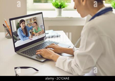 Médecin communiquant avec la mère et son fils à haute température et donner des recommandations en ligne sur ordinateur portable Banque D'Images