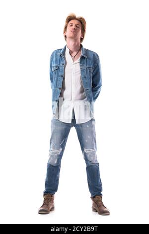 Jeune rebelle coq jeune homme beau en Jean regardant l'appareil photo avec la tête en arrière. Corps entier isolé sur fond blanc. Banque D'Images