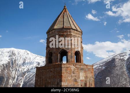 L'église de la Trinité de Gergeti est sous ciel nuageux par temps ensoleillé, Mont Kazbek, Géorgie Banque D'Images