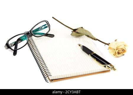 Bloc-notes, stylo, lunettes, calculatrice, fleurs de rose séchées isolées sur fond blanc. Banque D'Images