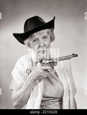 ANNÉES 1950 ANNÉES 1960, UNE FEMME ÂGÉE A UN SHARPSHOOTER PORTANT UN CHAPEAU DE COW-BOY JOUET BOUCHON PISTOLET REGARDER LA CAMÉRA - C3613 HAR001 HARS PERSONNES PERSONNAGE WESTERN GRANNY SENIOR ADULTE B&W CONTACT VISUEL SENIOR FEMME HUMORISTIQUE OLDSTERS OLDSTER PROTECTION PISTOLETS COWGIRL GUNSLINGER ZANY COMIQUE NON CONVENTIONNEL AÎNÉS COMÉDIE CONCEPTUELLE IMAGINATION IDIOSYNCRATIQUE AMUSANT EXCENTRIQUE PERSONNES ÂGÉES FEMME ARME À FEU ARME À FEU OUTLAW PISTOLET FUMANT PISTOLET ROBUSTE NOIR ET RACE BLANCHE DE RACE BLANCHE ERRATIQUE HAR001 ANCIEN MODE Banque D'Images