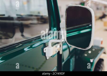 voiture verte sale dans la poussière vue sur la porte et le miroir sur une journée ensoleillée, gros plan sur le thème de l'auto. Banque D'Images