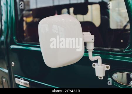 voiture verte sale dans la poussière vue sur la porte et le miroir sur une journée ensoleillée, gros plan sur le thème de l'auto. Banque D'Images