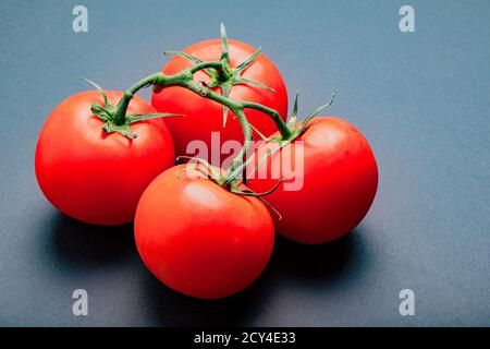 Quatre tomates sur la vigne rouge mûre Banque D'Images