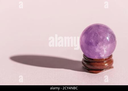 Cristal, minéral, boule transparente, sphère sur fond rose. Banque D'Images