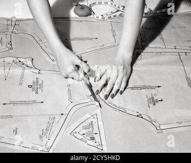 VUE AÉRIENNE DES ANNÉES 1940, ANNÉES 1950, D'UNE FEMME EN UTILISANT DES CISEAUX PIÈCES DE MOTIF EN TISSU POUR COUDRE DES VÊTEMENTS MAINS SYMBOLIQUES - S14564 HAR001 HARS COPIE ESPACE FEMMES PERSONNES ARTISANAT CONFIANCE COUTURE PIÈCES OBJECTIFS B&W COMPÉTENCES MÉTIER MÉTIERS DE HAUT NIVEAU À L'AIDE DE CONCEPTS COUTURIÈRE SYMBOLIQUE CRÉATIVITÉ COUTURE MOYENNE-ADULTE MOYENNE-ADULTE FEMME DE PRÉCISION NOIR ET MAINS BLANCHES D'ORIGINE ETHNIQUE CAUCASIENNE SEULEMENT HAR001 OLD FASHIONED Banque D'Images