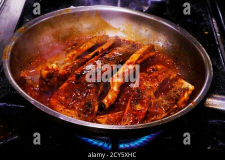 côtelettes de porc au barbecue collantes dans une casserole avec sauce chaude Banque D'Images