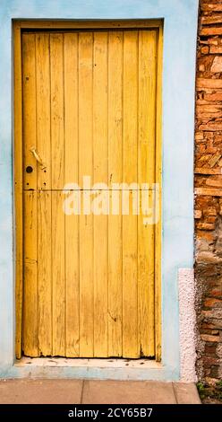 Trinidaad, Cuba 26 Nov 2017 - Porte Jaune sur bleu et mur de brique Banque D'Images