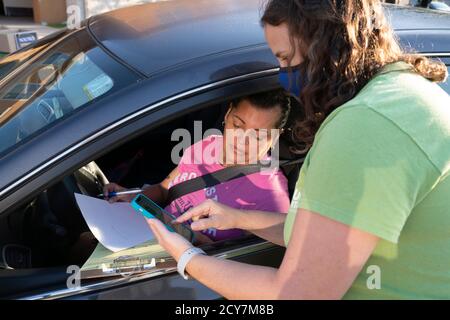 Austin, Texas, États-Unis. 1er octobre 2020. Karen GREEN(r), travailleuse des organismes de bienfaisance catholiques, aide Austinite IRMA FLORES avec sa demande d'inscription d'électeur pendant un trajet de quatre heures le 1er octobre 2020 à Austin. Plusieurs dizaines de résidents américains majoritairement hispaniques ont été inscrits dans l'effort non partisan. Crédit : Bob Daemmrich/ZUMA Wire/Alay Live News Banque D'Images