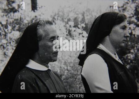 Belle photographie en noir et blanc vintage des années 1970 de deux religieuses catholiques du dimanche à la messe. Banque D'Images