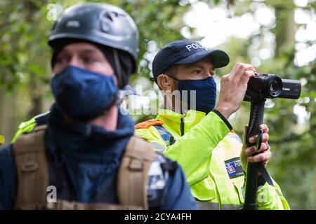 Aylesbury Vale, Royaume-Uni. 1er octobre 2020. Un policier de la vallée de la Tamise, travaillant avec les huissiers de l'équipe nationale d'expulsion, effectue une surveillance sur les militants anti-HS2 lors des expulsions d'un camp de protection de la faune dans l'ancienne forêt qui a inspiré Roald DahlÕs fantastique M. Fox à JonesÕ Hill Wood. Environ 40 activistes environnementaux et résidents locaux, dont certains vivent dans des maisons d'arbres de fortune à environ 60 mètres au-dessus du sol, ont été présents lors des expulsions à JonesÕ Hill Wood qui avait servi comme l'un des nombreux camps de protestation établis le long de la route des 106milliards de livres HS2 haute vitesse r Banque D'Images