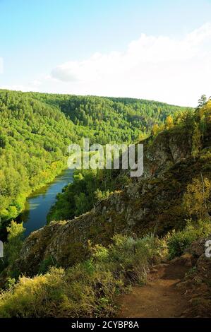 Une rivière calme qui traverse une forêt de conifères d'été dans un crevassé entre les montagnes. Berdsk Rocks, région de Novosibirsk. Banque D'Images