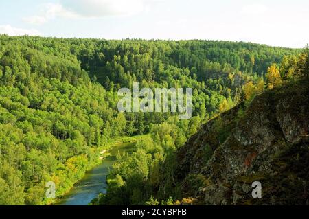 Une rivière calme qui traverse une forêt de conifères d'été dans un crevassé entre les montagnes. Berdsk Rocks, région de Novosibirsk. Banque D'Images