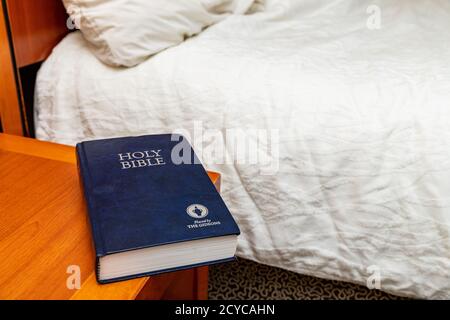 Bible Gideons sur la table de nuit dans la chambre d'hôtel Banque D'Images