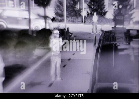 Détails avec des personnes vues sur un moniteur à partir d'une caméra de surveillance infrarouge/thermique. Banque D'Images