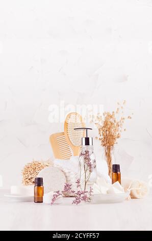 Produits cosmétiques pour le bain et accessoires beige en bois naturel dans un style écologique avec lavande dans un élégant intérieur blanc de salle de bains avec espace de copie, vertical. Banque D'Images