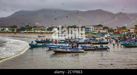 Puerto Lopez, ÉQUATEUR - 12 septembre 2018 - Les pêcheurs de terminer leur fixer des filets, bateaux de nettoyage, et en parlant avec des amis Banque D'Images