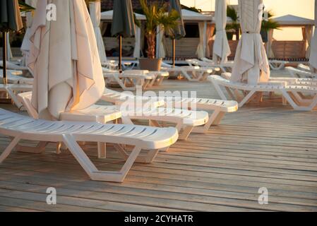 Parasols pliés et chaises longues sur un plancher en bois sur la plage de la mer, vacances d'été et Voyage. Banque D'Images