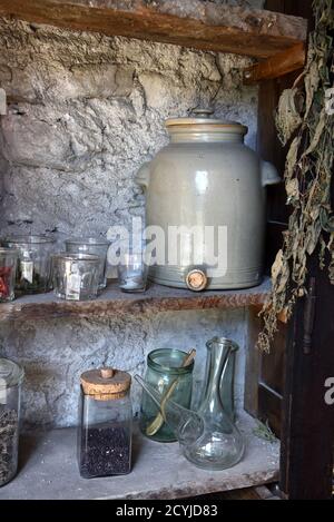 Étagères en bois d'époque ou étagère rustique ancienne, verrerie, verres, pots de rangement, pot et robinet en faïence antique ou bol de robinet dans l'intérieur de la cuisine ancienne Banque D'Images