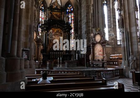 Homme solitaire priant à l'intérieur de la cathédrale Saint-Étienne ou Stephansdom à Vienne, Autriche, Europe. Les gens et la religion dans l'église catholique de Vienne Banque D'Images