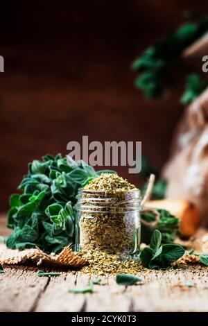 Origan sec et frais, arrière-plan en bois d'époque, style rustique, mise au point sélective Banque D'Images