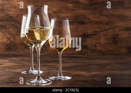 Ensemble vin blanc. Dégustation de vins, les variétés de vins blancs les plus populaires dans des verres à vin sur une table en bois vintage dans un style rustique, concentration sélective Banque D'Images