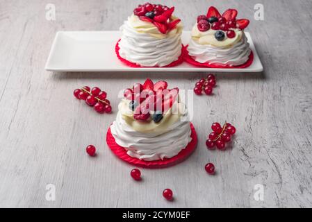 Gâteau à la meringue Pavlova avec crème et framboises, bleuets, fraises, raisins de Corinthe Banque D'Images