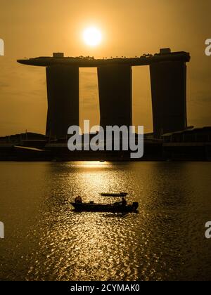 Singapour, SINGAPOUR - 11 FÉVRIER 2017 : lever du soleil à Marina Bay au-dessus de Marina Bay Sands Hotel à Singapour avec bateau dans l'eau. Marina Bay Sands, site touristique de Banque D'Images