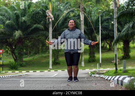 gros homme obèse faisant des exercices avec corde de saut en surpoids gars entraînement entraînement perte de poids 7sur le parc extérieur Banque D'Images