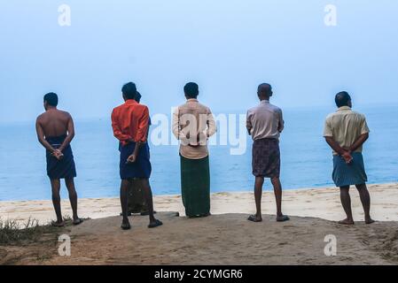 Pêcheurs indiens sur le bateau de pêche collectant de la sardine dans un panier fraîchement pêché dans les eaux profondes du Kerala Inde. Banque D'Images