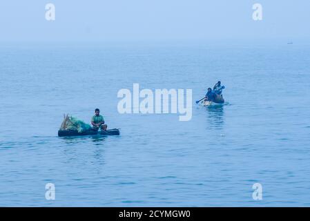 Pêcheurs indiens sur le bateau de pêche collectant de la sardine dans un panier fraîchement pêché dans les eaux profondes du Kerala Inde. Banque D'Images