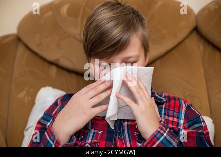 adolescente soufflant son nez dans un mouchoir en papier à la maison. Syndrome du virus respiratoire covid-19. Santé, Banque D'Images