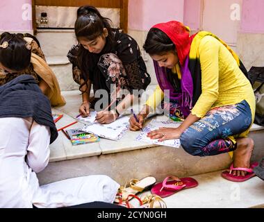 New Delhi, Inde, 20 févr. 2018 - Les jeunes femmes apprennent à dessiner des symboles religieux de temple Banque D'Images