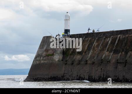 Pêcheurs sur la jetée de Porthcawl/Breakwater près du phare de pêche. Porthcawl, Bridgend South Wales Royaume-Uni Banque D'Images