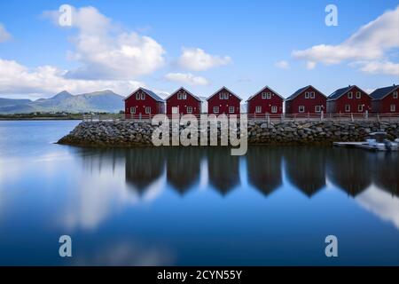 Célèbre attraction touristique village de pêcheurs de Hamnoy sur les îles Lofoten, Norvège avec des maisons de rorbu rouge et jaune. Eau calme et floue Banque D'Images