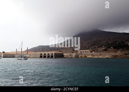 Ancienne usine Florio delle Tonnare de Favignana et Formica avec de lourds nuages de pluie enveloppent les montagnes dans la distance vue de port de Favignana Banque D'Images