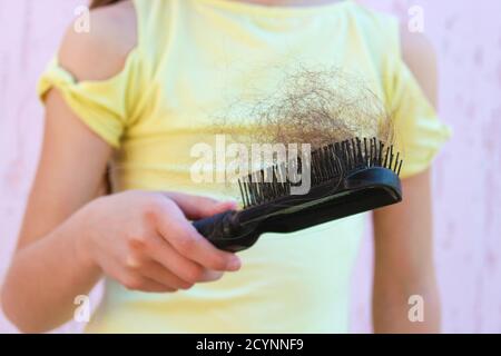 La fille est choquée par la quantité de cheveux qui est tombée. Banque D'Images