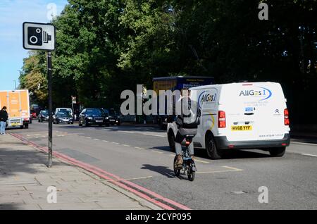 un homme fait un vélo électrique sur la route de l'arcade highgate londres, Royaume-Uni Banque D'Images