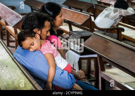 Enfant endormi sur l'épaule du père dans l'église historique Saint Francis, le lieu de sépulture de Vasco da Gama à fort Cochin; Kochi (Cochin), Kerala, Inde, Banque D'Images