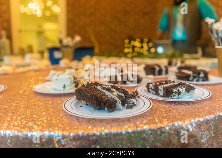 Gros plan d'un morceau de gâteau au chocolat dans des assiettes pendant une cérémonie de mariage Banque D'Images