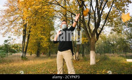 un homme dans un masque médical se réjouit à l'arrivée de l'automne, Banque D'Images