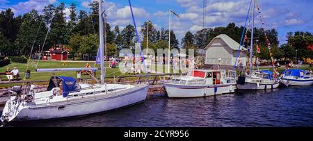 Göta kanal à Karlsborg, avec des bateaux à moteur amarrés et des voiliers le long de cette voie navigable idyllique en Suède. Banque D'Images