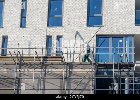 Construction / démantèlement d'échafaudages par un ouvrier de construction pour un nouveau projet de construction Banque D'Images