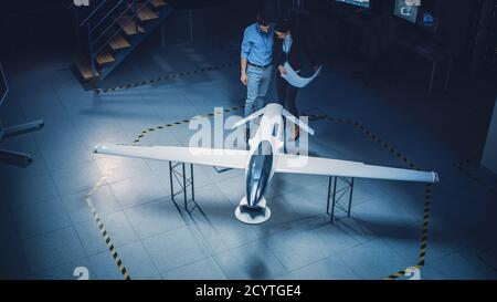 Réunion des ingénieurs aérospatiaux sur le prototype de Drone de véhicule aérien sans pilote. Les experts de l'aviation ont des discussions. Installation industrielle avec avion Banque D'Images