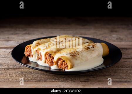 Délicieuses pâtes de cannelloni à la viande sur une table rustique en bois Banque D'Images